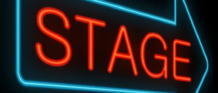 red stage sign in blue arrow on black background showing howto get to broadway auditions