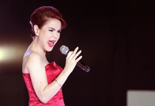 woman in red dress singing while holding a microphone